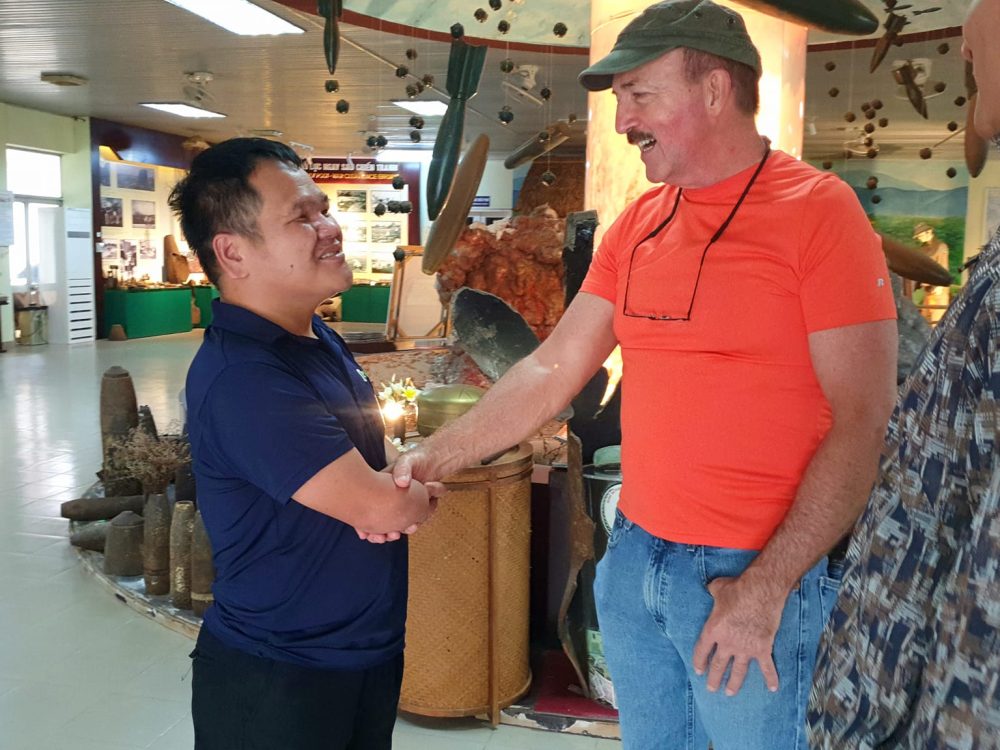 The warm handshake and friendly smile of the American veteran for the landmine victim working at the Mine Action Visitor Center © 2024 V-Explorer® All rights reserved.